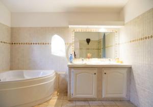 a bathroom with a tub and a sink and a mirror at Villa Santa Reparata di Balagna in LʼÎle-Rousse +9 photos