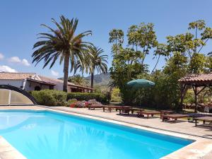 una piscina con mesas de picnic y una sombrilla en Your Island Finca El Picacho A, en Tegueste