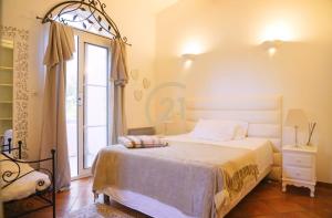 a bedroom with a bed and a large window at Villa Santa Reparata di Balagna in LʼÎle-Rousse