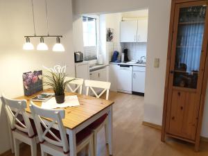 a kitchen and dining room with a wooden table and chairs at Wiesenweg W06 D in Laboe