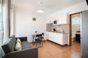 a living room with a couch and a table and a kitchen at Casa Sabrina, Terraza Vista Mar in Playa Honda +12 photos