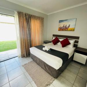 a bedroom with a large bed with red pillows at 473 On Cliff in Pretoria +52 photos