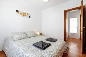 a bedroom with a bed with a black purse on it at Casa Sabrina, Terraza Vista Mar in Playa Honda