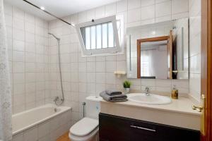 a bathroom with a sink and a tub and a toilet at Casa Sabrina, Terraza Vista Mar in Playa Honda