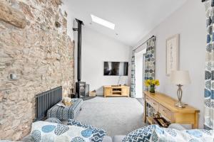 ペイントンにあるThe Dairy, Higher Yalberton Farmの石壁のリビングルーム