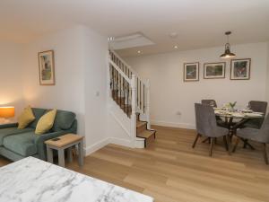 un salon avec un canapé et une salle à manger dans l'établissement Dalegarth Hall Farm Cottage 2, à Holmrook