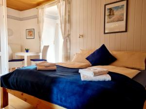 a bedroom with a blue bed with towels on it at Weingut Badischer Hof in Weiler