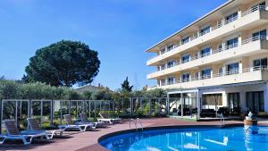 ein Hotel mit einem Pool vor einem Gebäude in der Unterkunft Apartamentos La Masia in L'Estartit