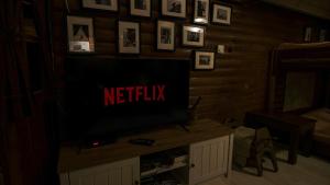 a television in a living room with the words netflix at katafygio-oiti in Pávliani