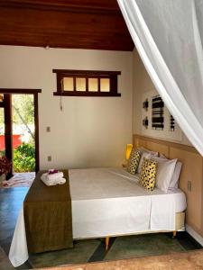 a bedroom with a large white bed with pillows at Pousada Varandas da Serra in Serra do Cipo