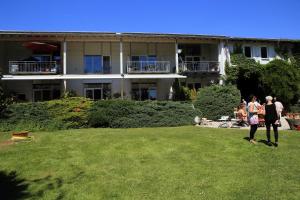 two people standing in the grass in front of a building at Apartment Flughafen Leipzig in Hayna