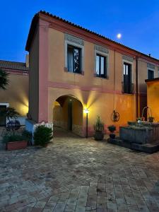 a large building with an archway in a courtyard at Casale Romano Resort e Relais in Motta Camastra