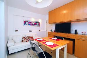 a living room with a table and a white couch at Quarto&Sala a 150m da Praia | U052 in Rio de Janeiro