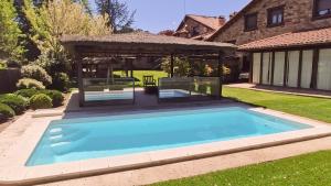 una piscina en un patio con cenador en Saika Rural, en Manjirón