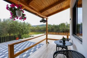 a patio with a table and chairs on a deck at Olive Oasis Studio in Berat