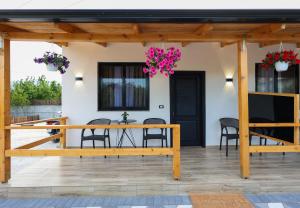 a patio with a wooden table and chairs at Olive Oasis Studio in Berat