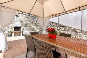 una mesa de madera con sillas y un banco con flores. en Residence Tatiana A4, en Tremosine Sul Garda