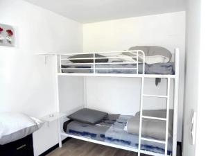two white bunk beds in a room at Maison de 4 chambres avec jardin amenage a Castelnau de Mandailles in Castelnau-de-Mandailles