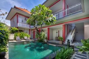 a villa with a swimming pool in front of a house at Angkul Angkul Beach Inn Kuta by Kamara in Kuta