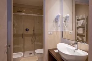 La salle de bains est pourvue d'un lavabo, d'une douche et de toilettes. dans l'établissement Hotel Boston, à Stresa