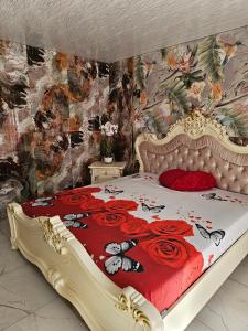 ein Schlafzimmer mit einem Bett mit einer roten Bettdecke mit Rosen in der Unterkunft Willa Magdalena in Świnoujście