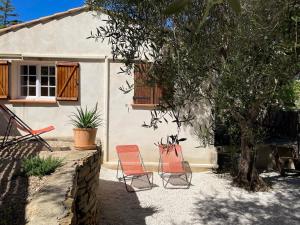 deux chaises assises devant une maison dans l'établissement Maison au calme avec jardin et parking, proche de tout !, à La Ciotat