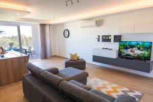 モスタにあるAmazing Family Apartment In Mosta By Homelyのソファと薄型テレビのあるリビングルーム