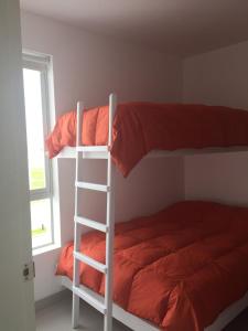 a white bunk bed with a ladder next to a window at Paracas Beach Vacation Rentals in Paracas +17 photos