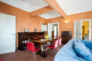 sala de estar con mesa y sillas rojas en Villa Eremo Sant'Emilia, en Trecastagni