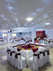 a banquet hall with white tables and chairs and lights at Hotel Casa Azul in Sonsón