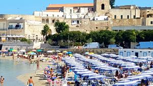 una spiaggia con un mucchio di ombrelloni blu e bianchi di Oikia Vacanze Casa di Chica a Otranto