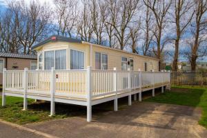 a mobile home with a white fence at SBL38 Caravan at Camber Sands - quiet location in Camber