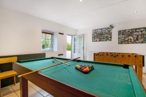 a room with a pool table with paddles on it at Ferienwohnung Coni in Langballig