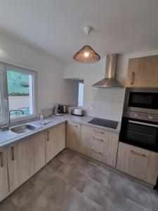 a kitchen with a sink and a stove top oven at Appartement Mers les Bains à deux pas de la plage. in Mers-les-Bains