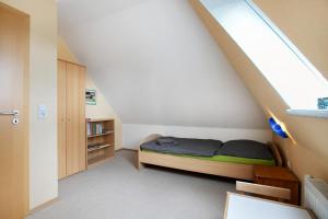 a small bedroom with a bed under the stairs at Ferienwohnung Coni in Langballig