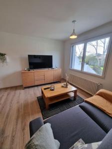a living room with a couch and a coffee table at Appartement Mers les Bains à deux pas de la plage. in Mers-les-Bains