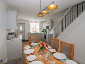 uma sala de jantar com uma mesa com pratos e flores em Dalegarth Hall Farm Cottage 1 em Holmrook