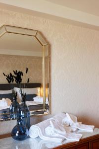 ein Bad mit einem Spiegel und einem Tisch mit Handtüchern in der Unterkunft Hotel Schiff am See in Murten