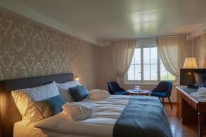 Dormitorio con cama, escritorio y TV en Hotel Schiff am See en Murten