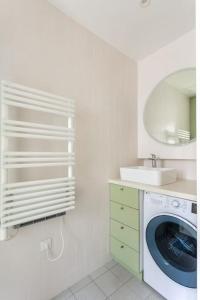ein Badezimmer mit einer Waschmaschine und einem Waschbecken in der Unterkunft Bastille nest in Paris in Paris