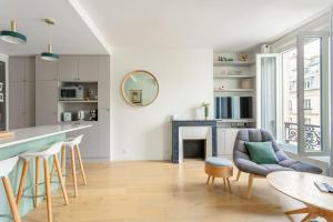 eine Küche und ein Wohnzimmer mit einem Tisch und Stühlen in der Unterkunft Bastille nest in Paris in Paris