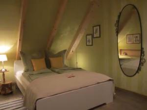 a bedroom with a bed and a large mirror at Koras Dachkammer in Ribnitz-Damgarten