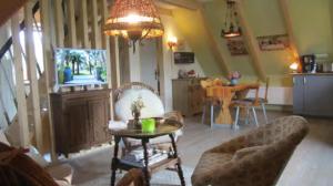 a living room with a chandelier and a table with a chair at Koras Dachkammer in Ribnitz-Damgarten