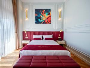 um quarto com uma grande cama vermelha com um quadro na parede em New Inn Hotel Old Town em Istambul