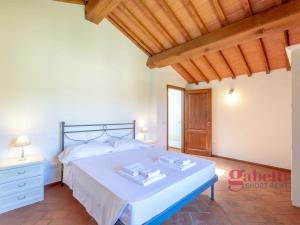 1 dormitorio con cama blanca y techo de madera en La Filanda - I Borghi Della Selvaccia, en Cennina