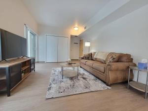 a living room with a couch and a table at HUGE New Apartment Next to Mayo, Free Parking in Rochester