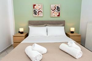 a bedroom with a bed with towels on it at Dioni Apartments in Plataria