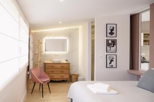 a bedroom with a bed and a desk and a chair at le 47, une pause à la campagne in Duisans