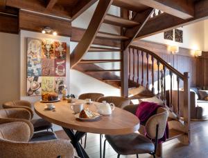 uma sala de jantar com uma mesa de madeira e cadeiras em Le Hameau du Kashmir em Val Thorens