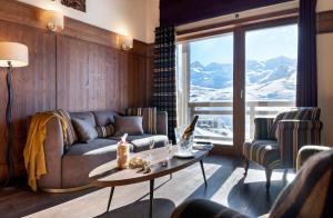 a living room with a couch and a table at Le Hameau du Kashmir in Val Thorens